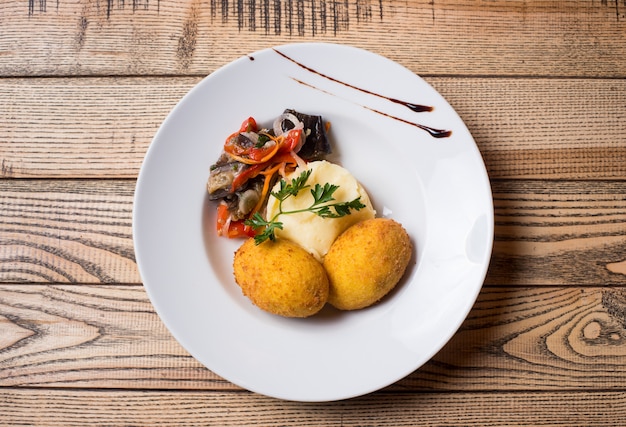 Kartoffelpüree mit einem Schnitzel im Teig und Salat