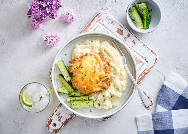 Kartoffelpüree mit schnitzel und gurke, draufsicht.