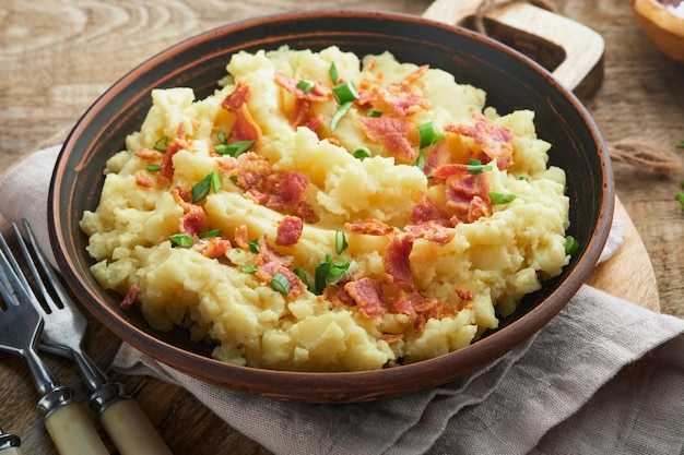 Kartoffelpüree Speck-Kartoffelpüree mit Frühlingszwiebelpfeffer und Cheddar-Käse in Schüssel auf alten hölzernen Hintergründen Köstliche cremige Kartoffelpüree Ansicht von oben