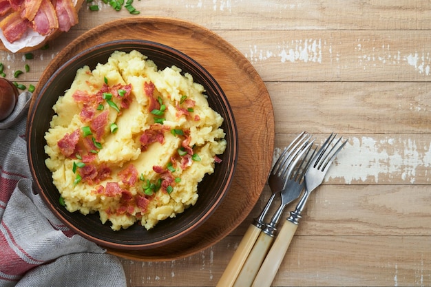 Kartoffelpüree Speck-Kartoffelpüree mit Frühlingszwiebelpfeffer und Cheddar-Käse in Schüssel auf alten hölzernen Hintergründen Köstliche cremige Kartoffelpüree Ansicht von oben