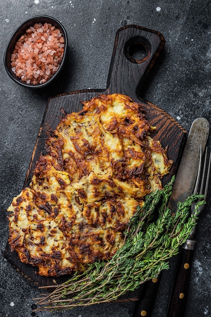 Kartoffelpuffer mit Kräutern und Salz auf Holzbrett