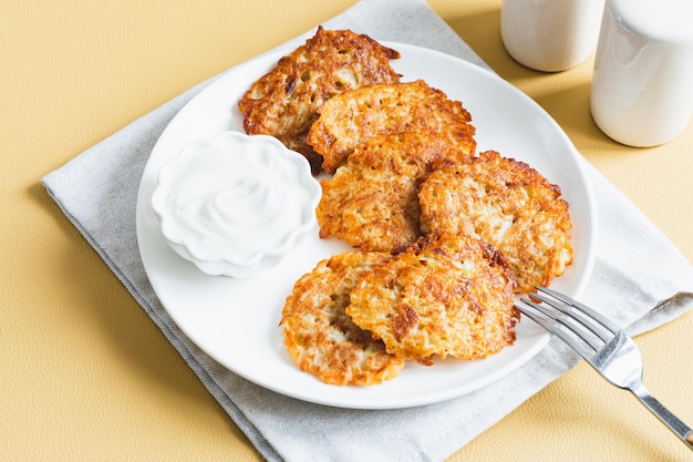 Kartoffelpuffer oder Latkes oder Draniki mit saurer Sahne Ukrainisches Essen Ein geriebenes Kartoffelgericht aus Deruny oder Draniki