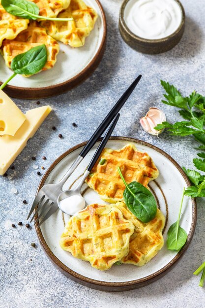 Kartoffelwaffeln mit erbsen-paprika-käse und kräutern ein schneller snack im teller