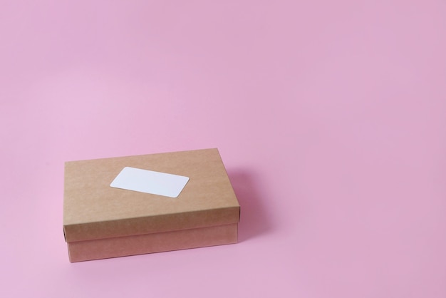 Karton Bastelkasten mit Abdeckung auf rosa Hintergrund Draufsicht. Das Konzept der Lieferung