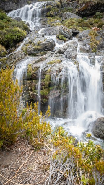 Kaskadierender Wasserfall mit seidigem Wasserporträt, aufgenommen auf der Routeburn-Strecke in Neuseeland