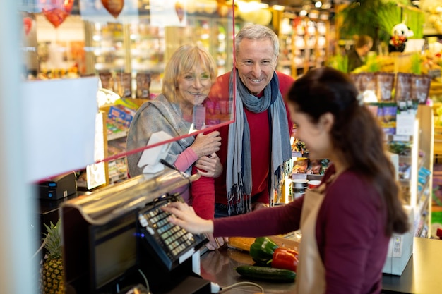 Kassiererin im Chat mit Kunden im Supermarkt