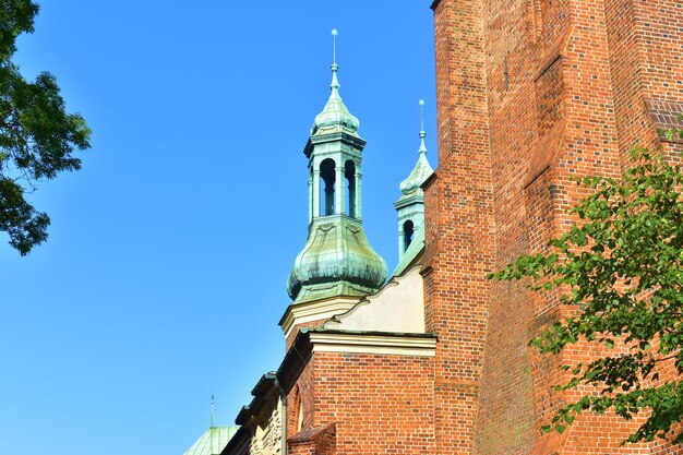 Kathedralentürme mit grüner Spitze und roter Backsteinmauer der katholischen Kirche Posen, Polen