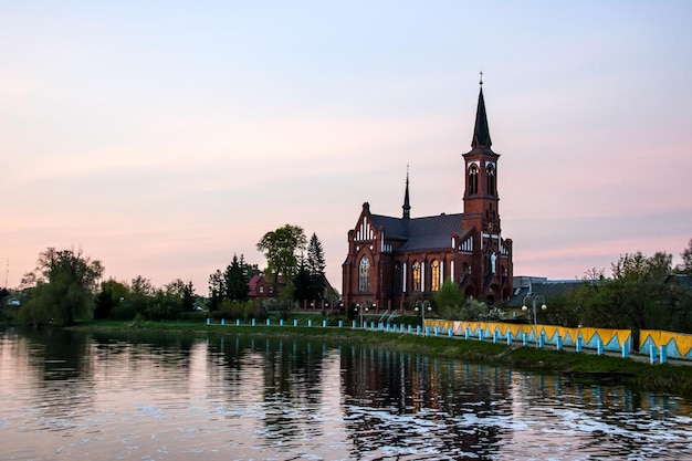 Katholische Kirche aus rotem Backstein bei Sonnenuntergang