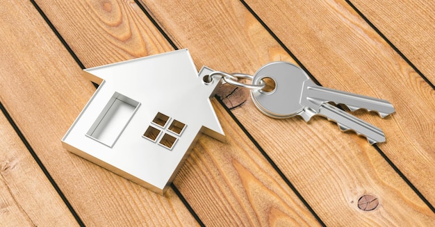 Kauf eines Hauses mit zwei Hausschlüsseln auf Holzhintergrund