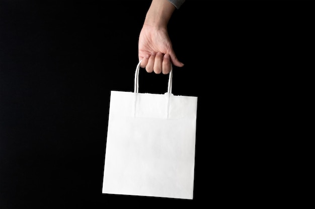 Kaufen am Black Friday Sale Hand mit einer ökologischen Einkaufstasche aus Kraft