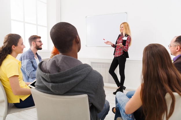 Kaufmännische Ausbildung. Rednerin, die einen Vortrag auf einer Geschäftstagung für ein multiethnisches Publikum in der weißen Halle hält, Kopierraum