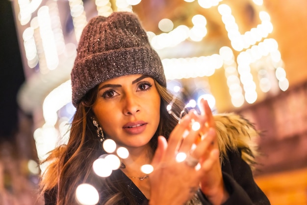 Kaukasier in der Stadt bei Nacht neben Weihnachtslichtern