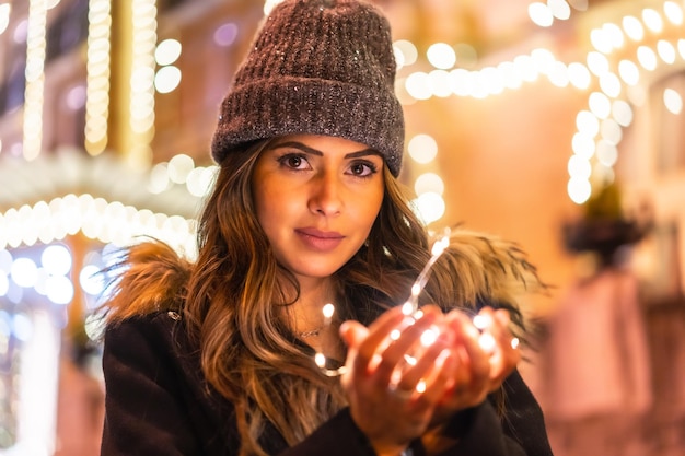 Kaukasier nachts in der Stadt neben Weihnachtslichtern