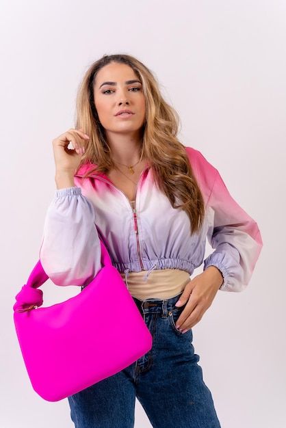 Kaukasische blonde Frau mit einer rosa Tasche auf einem Modestudio des mittleren Schusses des weißen Hintergrundes