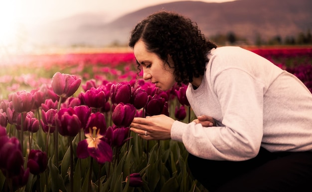 Kaukasische erwachsene Frau, die frische Tulpenblumen riecht