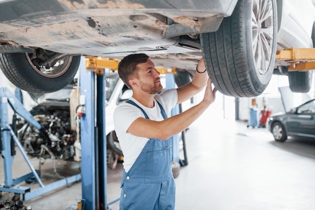 Kaukasische Ethnizität. Mitarbeiter in der blau gefärbten Uniform arbeitet im Autosalon