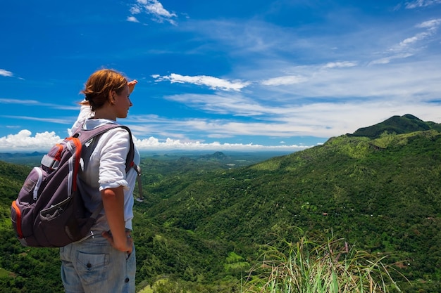 Kaukasische Frau, die auf Berg und Tal steht und schaut