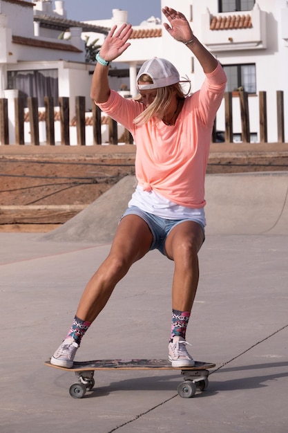 Kaukasische Frau, die einen Gleittrick im Skatepark macht