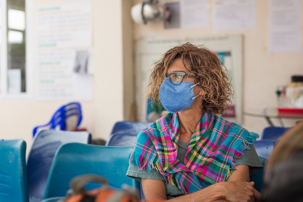 Kaukasische Frau, die Hygienemaske drinnen beim Reisen in Vietnam trägt. Tourist im Wartezimmer mit medizinischem Maskenschutz gegen das Risiko des neuen Corona-Virus covid-19 in Asien