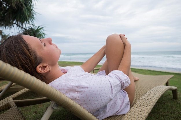 Kaukasische Frau, die sich im Stuhl in der Nähe des Indischen Ozeans in Srilanka entspannt