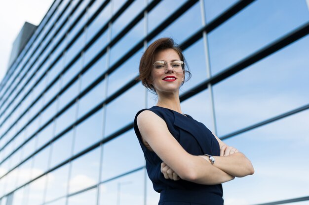 Kaukasische Frau in Bürokleidung nahe dem Bürogebäude