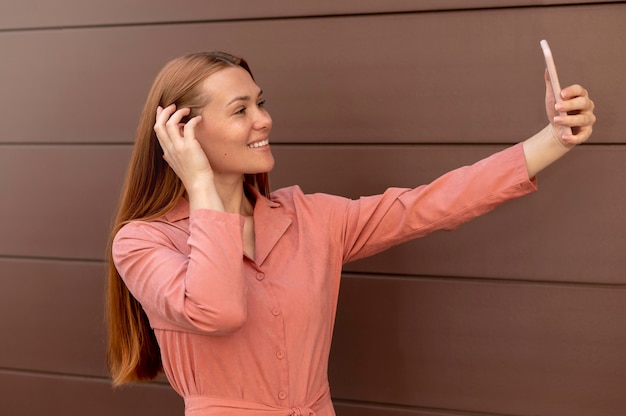 Kaukasische Frau macht ein Selfie mit ihrem Smartphone