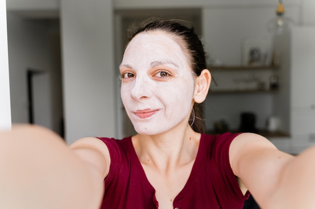 Kaukasische Frau mit Gesichtsmaske Live-Streaming als Beauty-Blogger