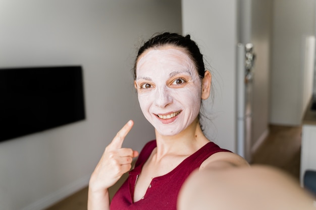Kaukasische Frau mit Gesichtsmaske Live-Streaming als Beauty-Blogger