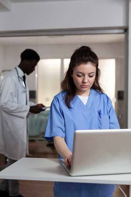 Kaukasische Frau mit Laptop am Schreibtisch in der Krankenstation