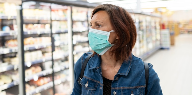 Kaukasische Frau mit medizinischer Maske einkaufen