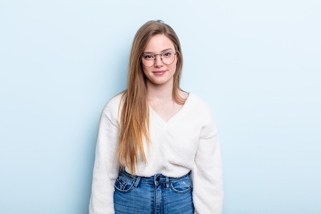 Kaukasische Frau mit roten Haaren, die positiv und selbstbewusst lächelt und zufrieden, freundlich und glücklich aussieht