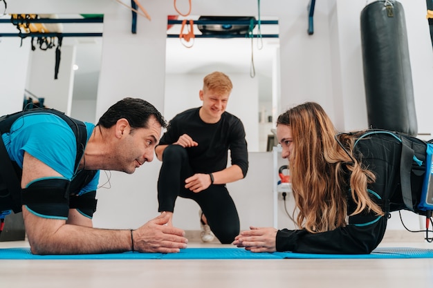 Kaukasische Frau und ein Mann mittleren Alters, der Planken während des High-Fiving macht