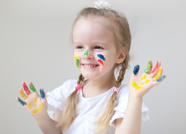 Kaukasische kleines Mädchen-Malerei mit den bunten Handfarben zu Hause die Früherziehung, die für Schulvorschulentwicklungs-Kinderspiel sich vorbereitet