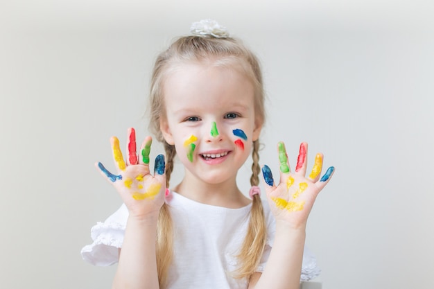 Kaukasische kleines Mädchen-Malerei mit den bunten Handfarben zu Hause die Früherziehung, die für Schulvorschulentwicklungs-Kinderspiel sich vorbereitet