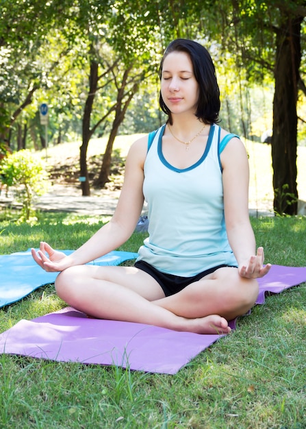 Kaukasische Mädchen üben Meditation im Park. Entspannende Aktivität.