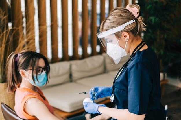 Kaukasische Patientin, die gegen Coronavirus geimpft wird, das Covid-Impfstoff erhält. Intramuskuläre Injektion während des Arzttermins im Krankenhaus. Covid-19-Impfung.