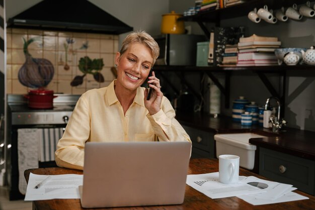 Kaukasische Seniorin arbeitet von zu Hause aus und telefoniert