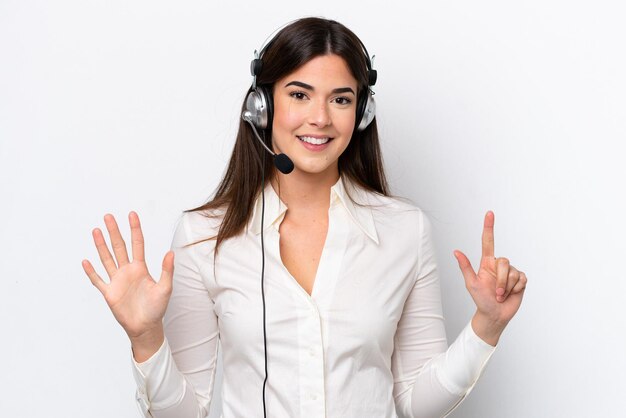 Kaukasische Telemarketer-Frau, die mit einem Headset arbeitet, das auf weißem Hintergrund isoliert ist und sieben mit den Fingern zählt