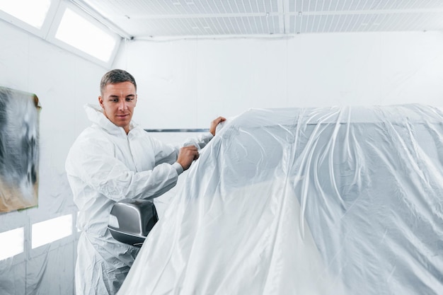 Kaukasischer Automechaniker in Uniform arbeitet in der Garage