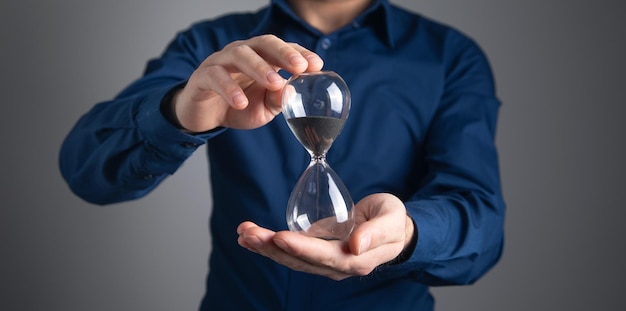 Kaukasischer Geschäftsmann zeigt eine Sanduhr Zeitmanagement