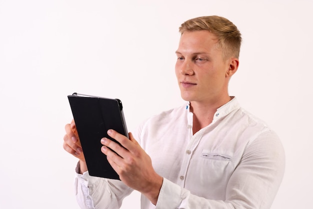 Kaukasischer Geschäftsmannmann mit einer Tablette, die E-Mails auf einem weißen Hintergrund betrachtet