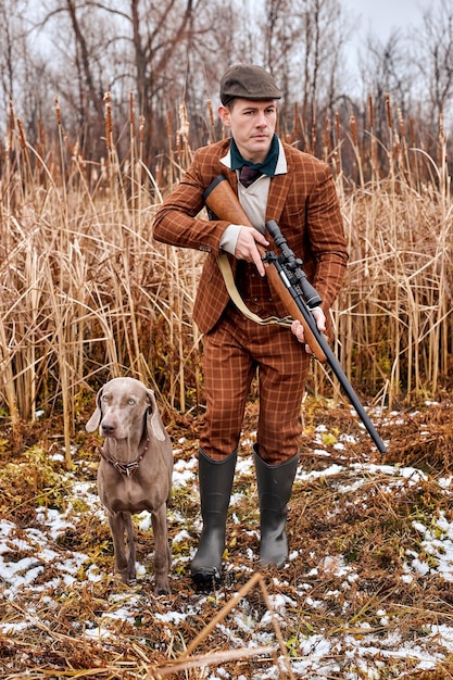 Kaukasischer Jäger mit Waffe und Wandern im Wald Gewehrjäger im ländlichen Gebiet Herbstjagd hu