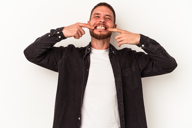 Kaukasischer Jüngling mit Diastema isoliert auf weißem Hintergrund lächelt und zeigt mit den Fingern auf den Mund.