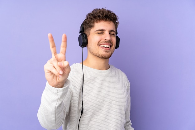 Kaukasischer Mann auf lila hörende Musik und Gesang