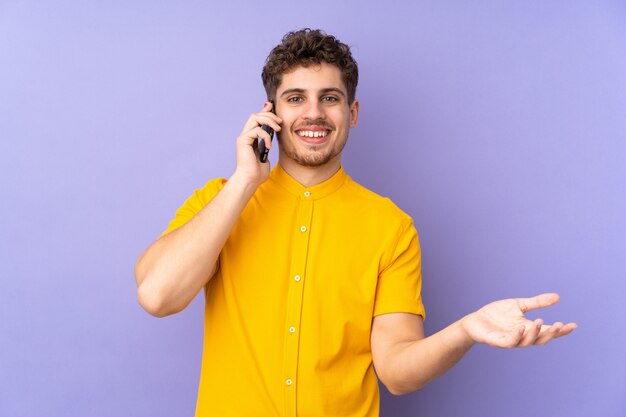 Kaukasischer Mann auf Purpur, der ein Gespräch mit dem Handy mit jemandem hält