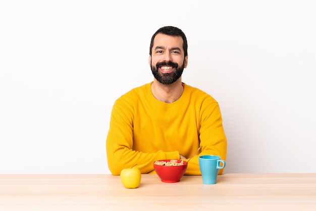 Kaukasischer Mann, der Frühstück in einem Tisch hält und die Arme in Frontalposition verschränkt