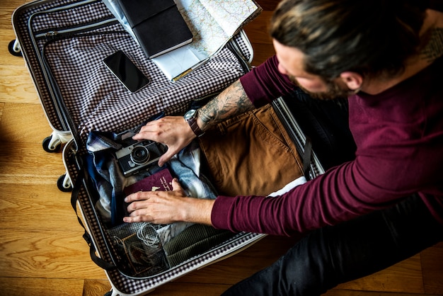 Kaukasischer Mann, der Gepäck für eine Reise packt