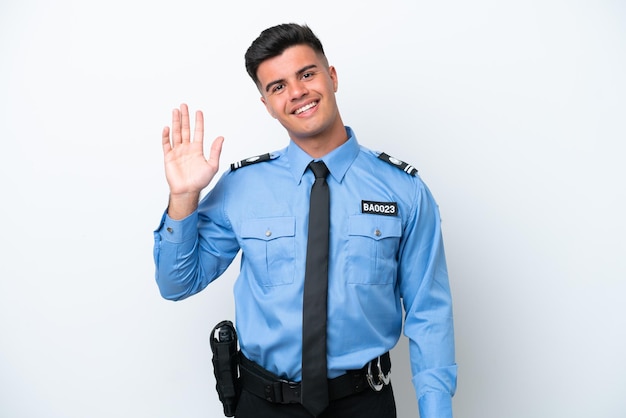 Kaukasischer Mann der jungen Polizei lokalisiert auf weißem Hintergrund, der mit der Hand mit glücklichem Ausdruck salutiert