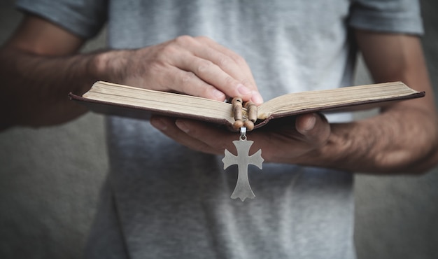 Kaukasischer Mann, der über Bibel betet.