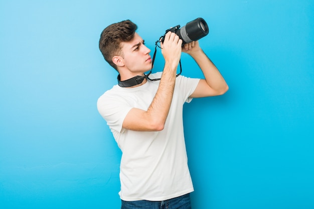 Kaukasischer Mann des Jugendlichen, der Fotos mit einer Spiegelreflexkamera macht